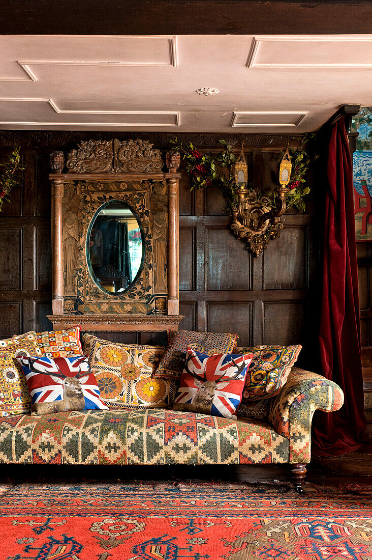 Union jack cushions on sofa in panelled drawing room of Cheltenham country home Gloucestershire England UK