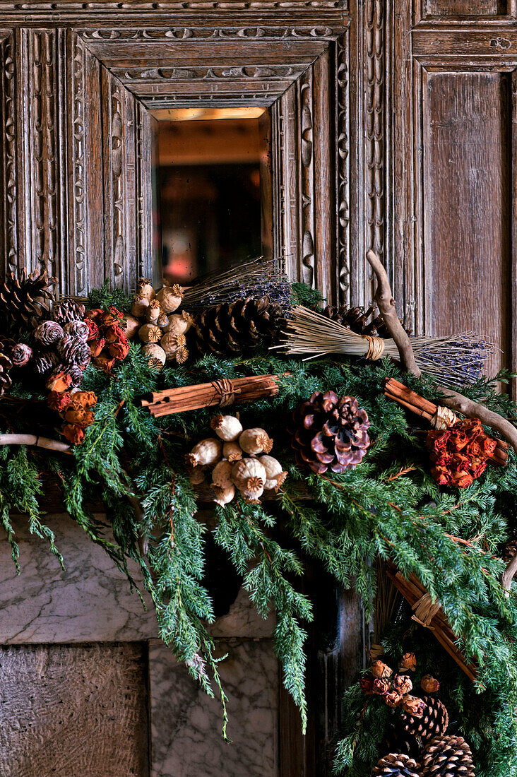 Geschnitzter Holzspiegel und natürliche Weihnachtsdekoration im Landhaus in Cheltenham Gloucestershire England UK