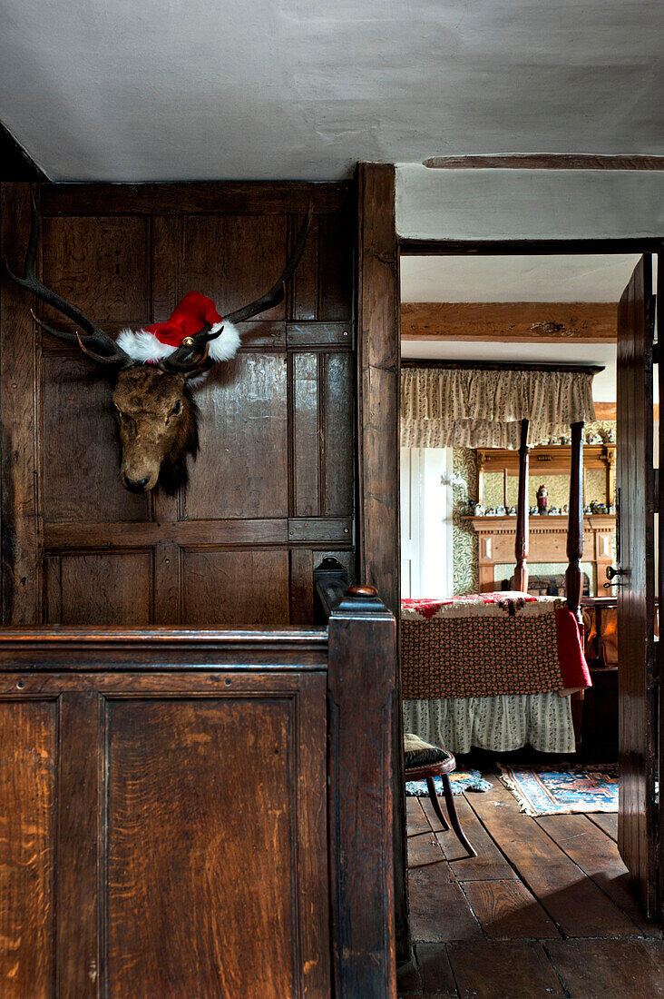 Blick durch eine Tür mit einer Jagdtrophäe im Schlafzimmer eines Landhauses in Cheltenham Gloucestershire England UK