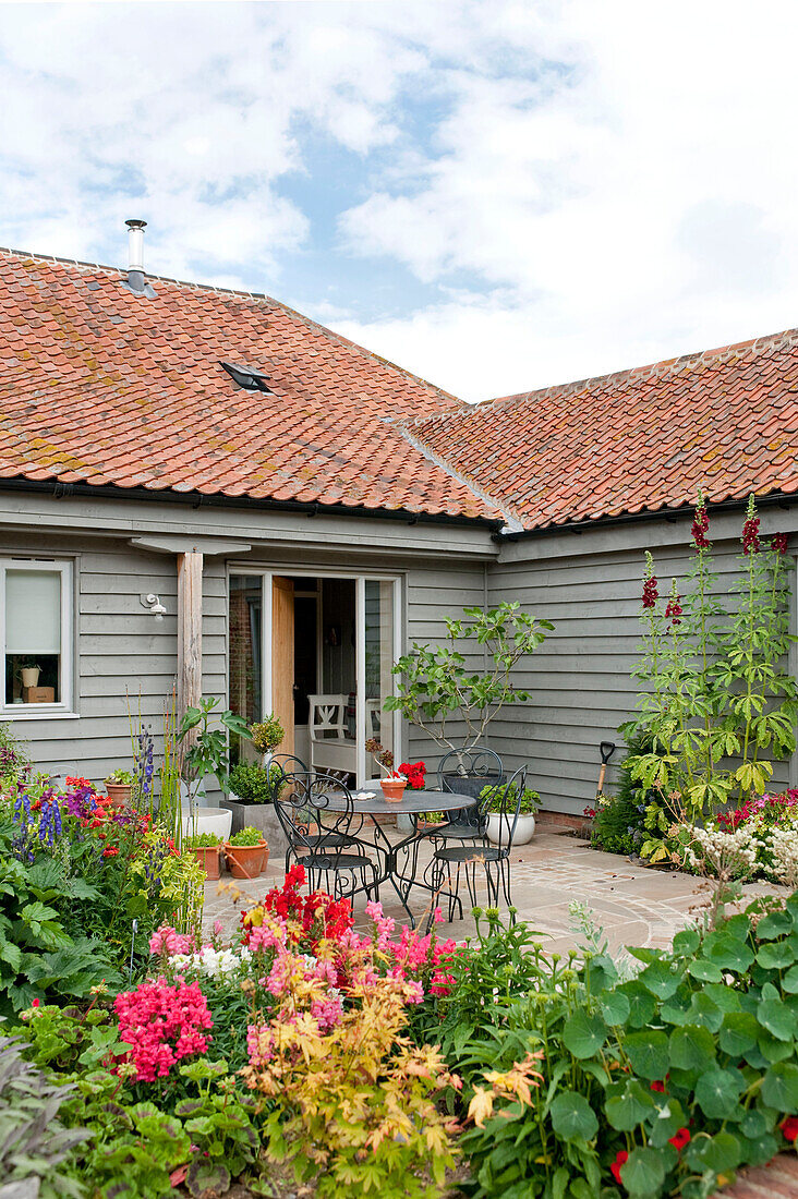 Terrasse im Garten vor einem Haus mit Klappe in Suffolk England UK