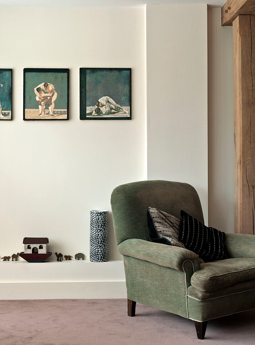 Sessel und Kunstwerk mit Holzbogen auf Regal in Familienhaus in Suffolk England UK