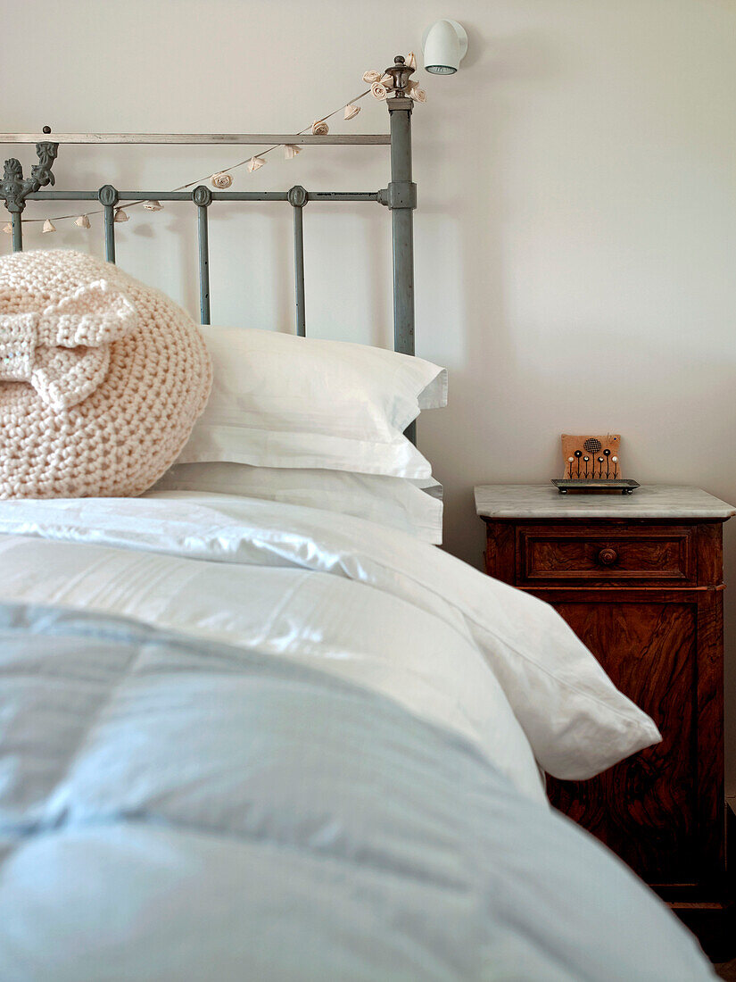 Gehäkelte Kissenhülle auf dem Bett mit marmoriertem Nachttisch im Schlafzimmer eines Hauses in Suffolk England UK