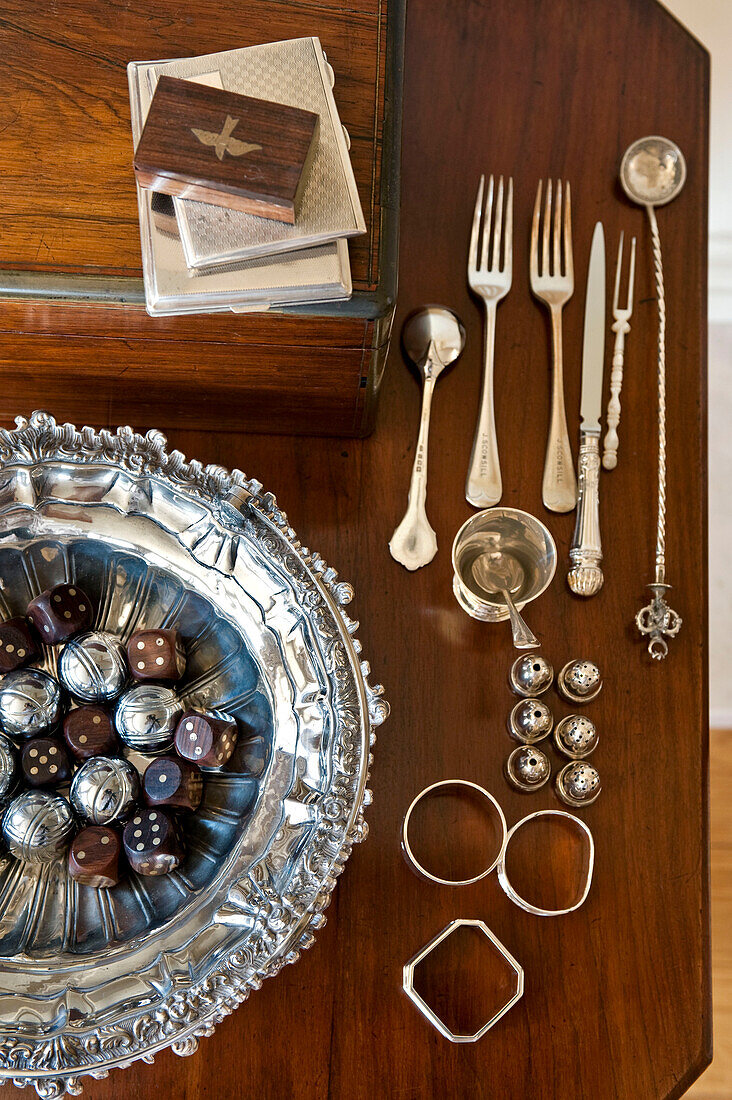 Wooden dice and chocolates with silverware on wood tabletop in Canterbury home England UK