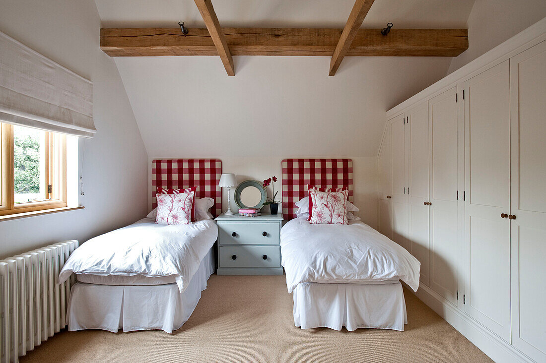 Rot und weiß karierte Kopfteile in einem Zweibettzimmer mit Balken in einem Haus in Canterbury, England, UK