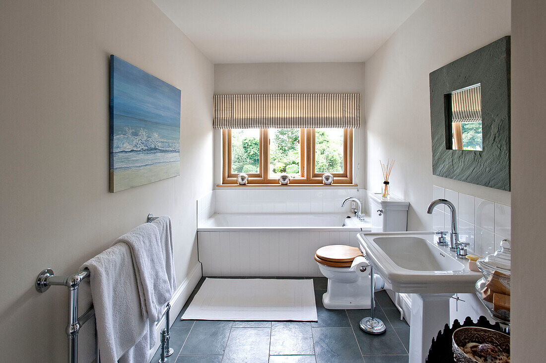 Quadratischer gerahmter Spiegel und Kunstwerk im Badezimmer eines Hauses in Canterbury, England, UK