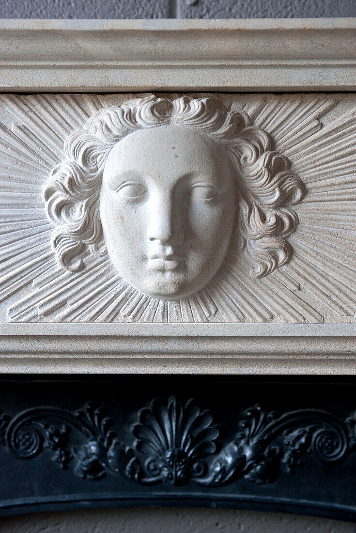 Geschnitztes Gesicht auf dekorativem Kaminsims in historischem Haus in Yeovil, Somerset, England UK