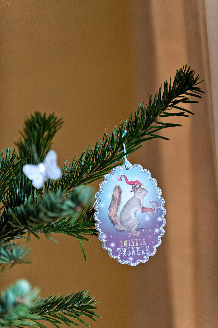 Weihnachtsbaumschmuck auf einem Tannenzweig im Haus der Familie Forest Row, Sussex, England, UK