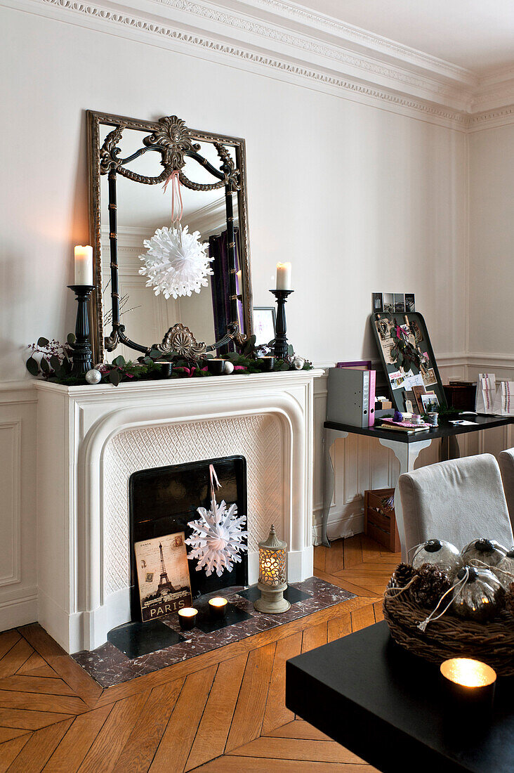 Schneeflocken-Weihnachtsdekoration und Vintage-Spiegel im Kamin einer Pariser Wohnung, Frankreich