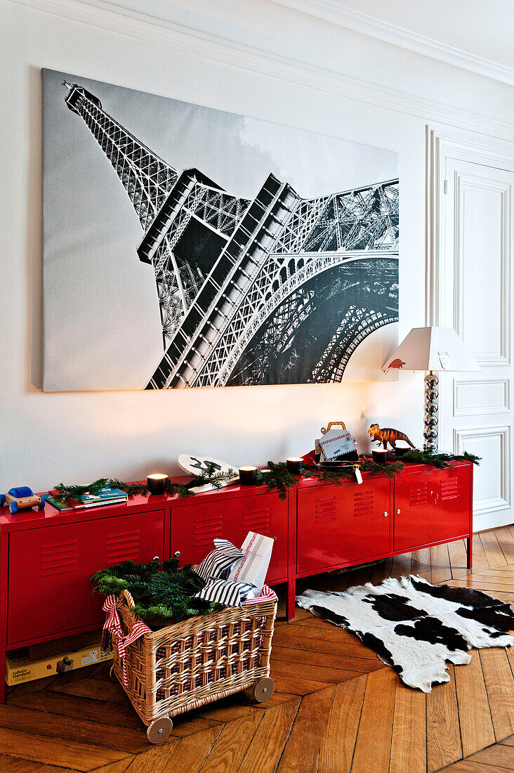 Großer Druck des Eiffelturms über rotem Sideboard mit Weihnachtsdekoration in Pariser Wohnung, Frankreich