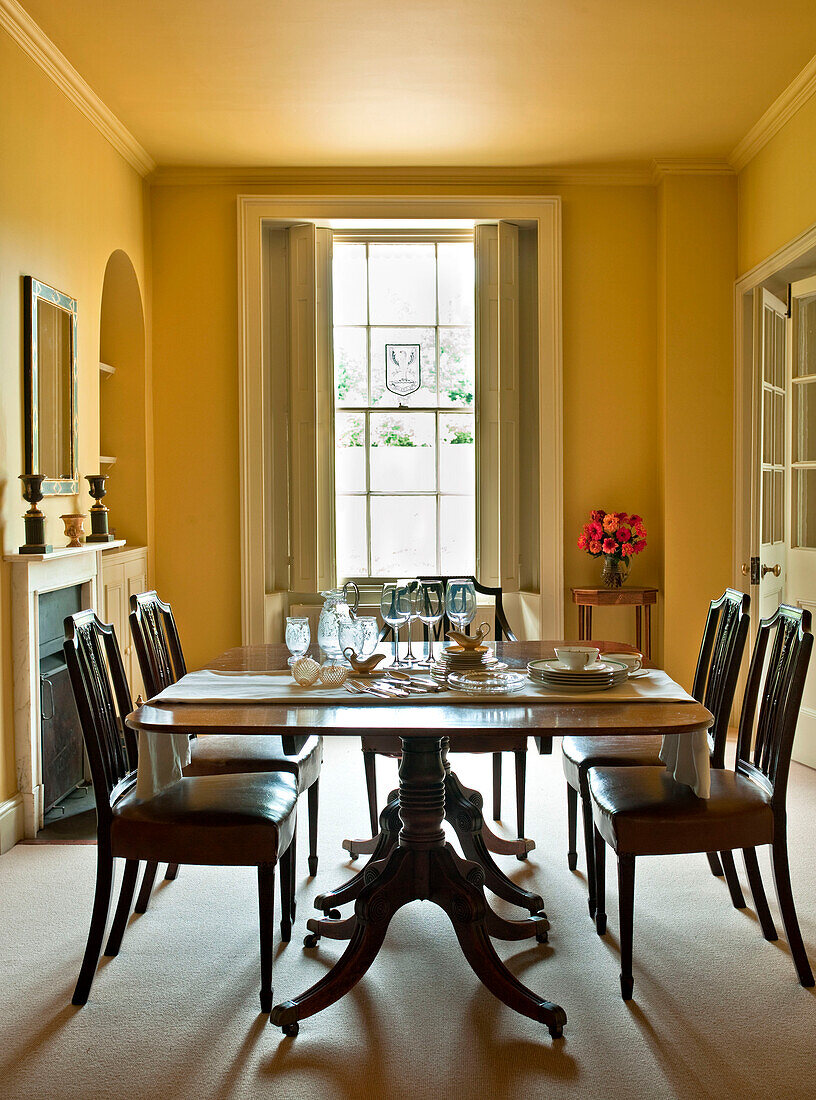 Gläser auf dem Tisch im gelben Esszimmer eines Landhauses in Suffolk, England UK