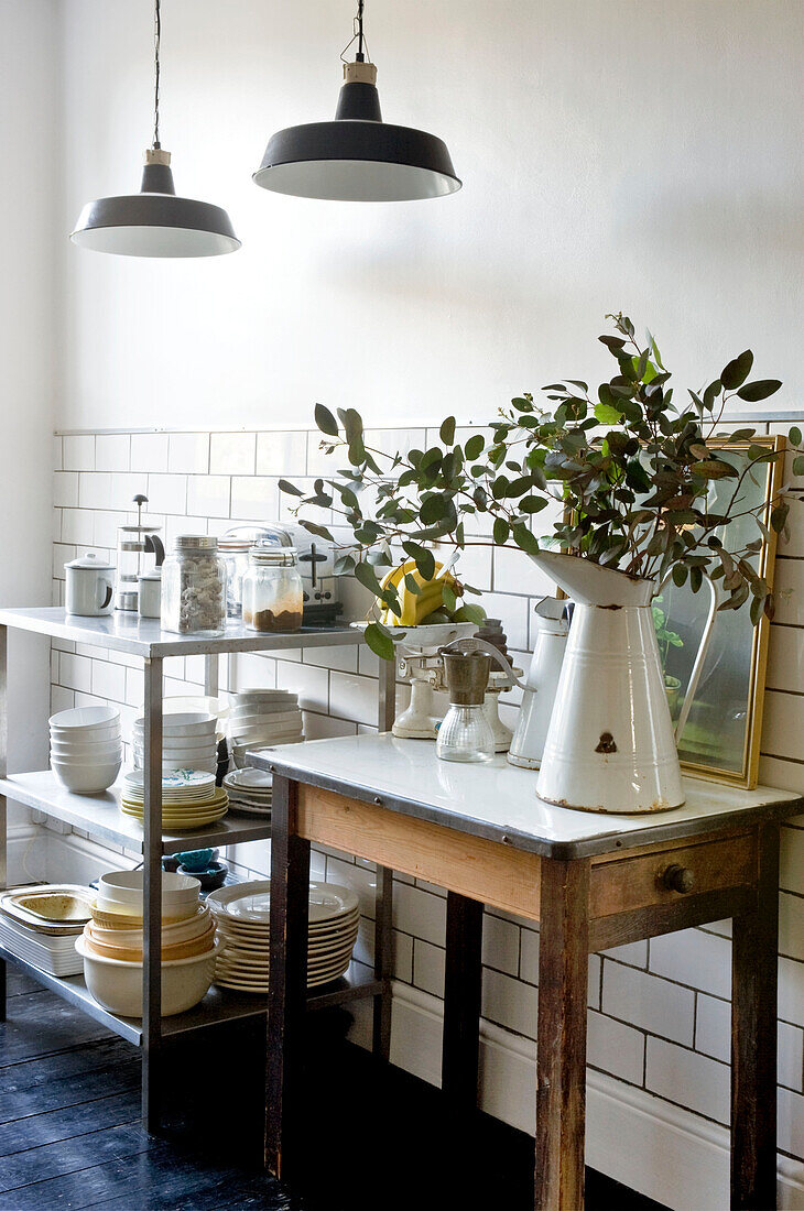 Plates stacked on service trolley in tiled kitchen of London home, UK