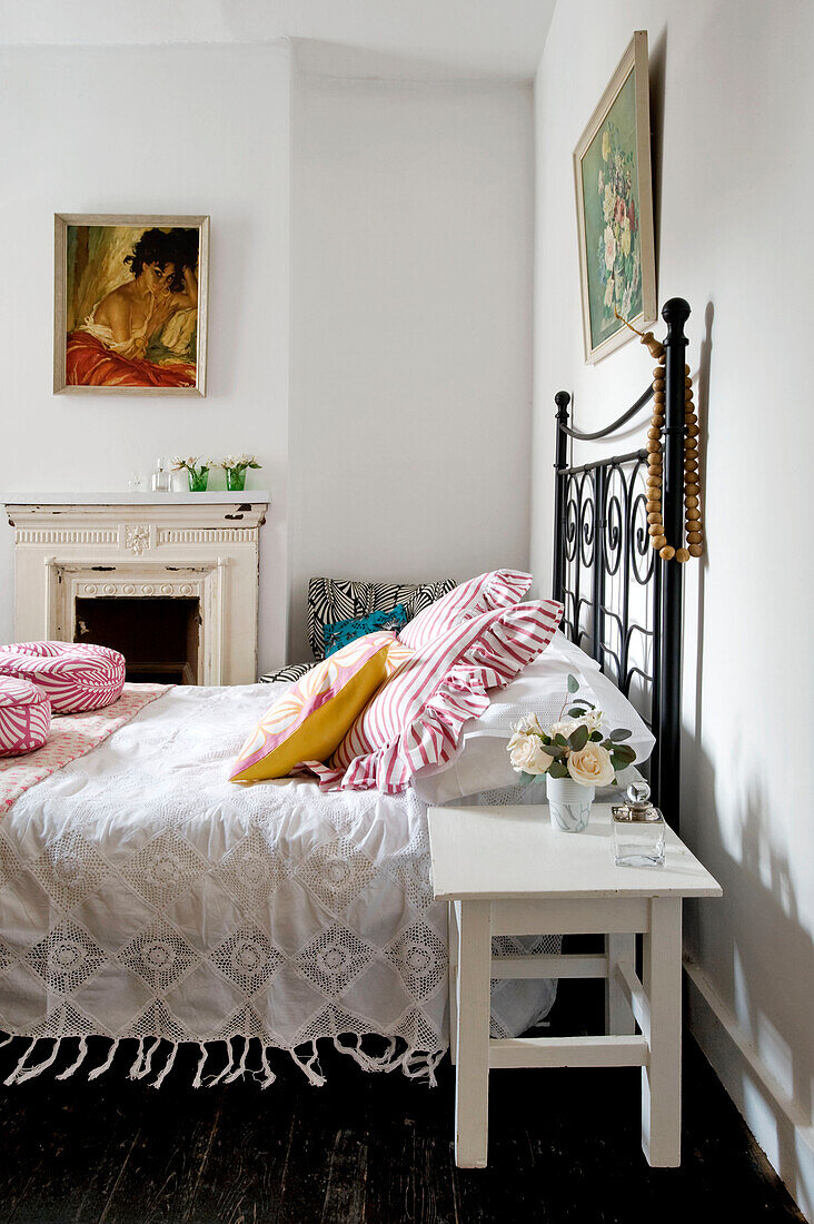 Cut roses at bedside with artwork in London home, UK