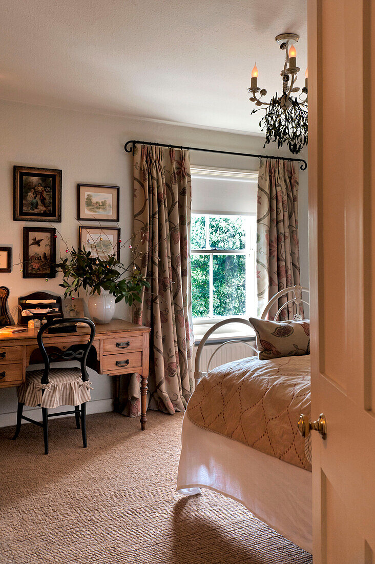 Dressing table with chair and artwork at bedroom window in Walberton home, West Sussex, England, UK