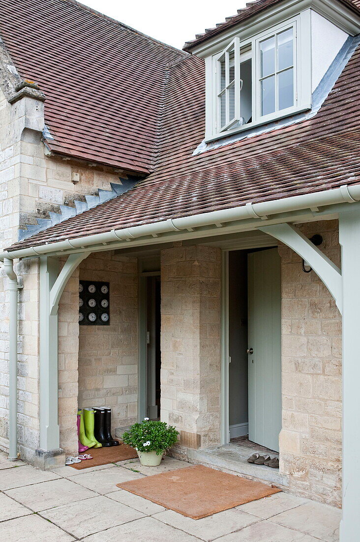 Tiled porch entrance with door mat and boots, Buckinghamshire home, England, UK