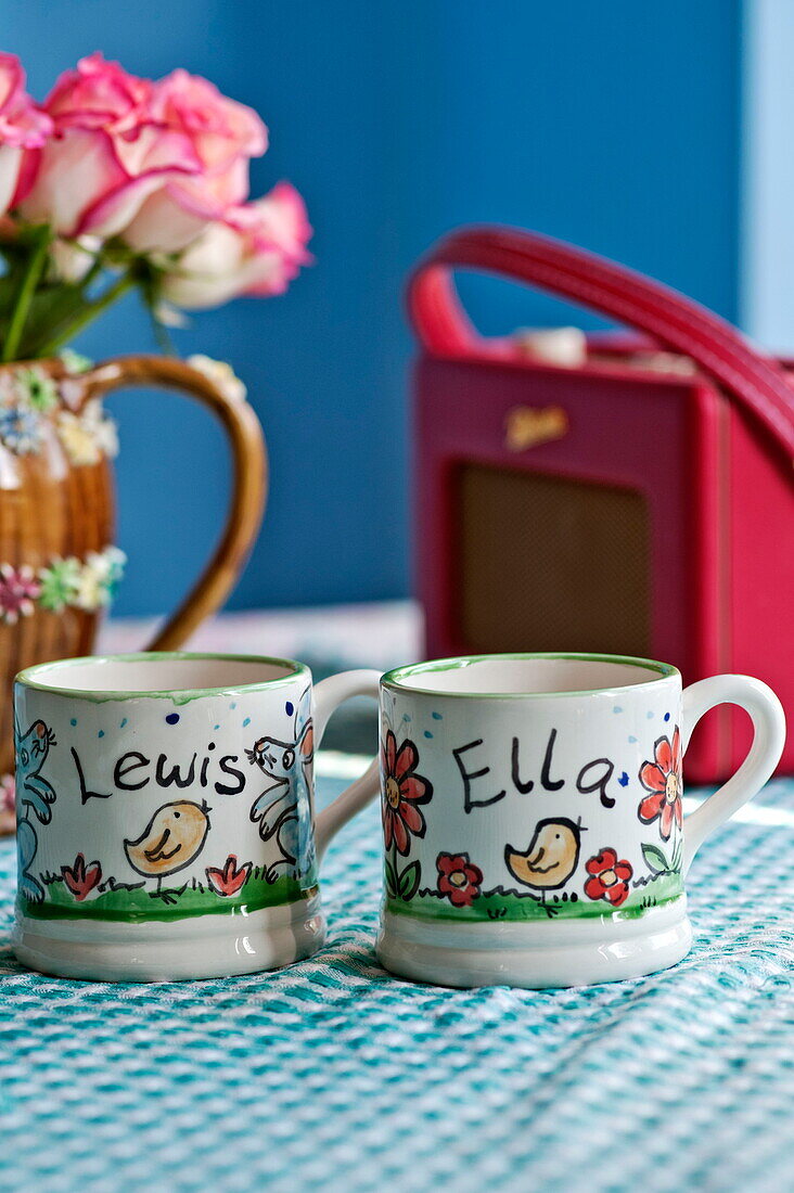 Personalised cups with vintage radio in kitchen of Bovey Tracey family home, Devon, England, UK