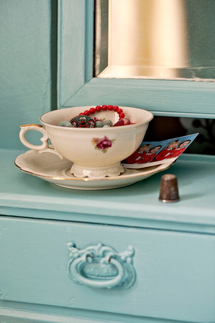 Vintage cup and saucer on painted dressing table in bedroom of Bovey Tracey family home, Devon, England, UK