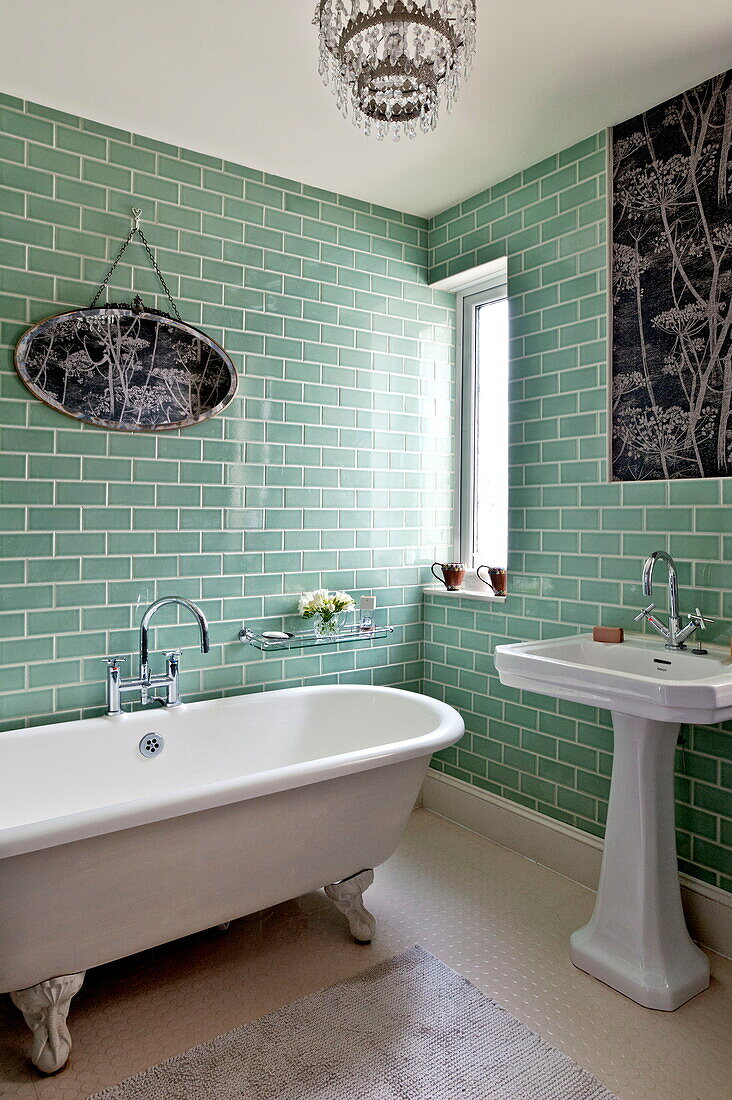 Pedestal basin and freestanding bath in green tiled bathroom of Bovey Tracey family home, Devon, England, UK