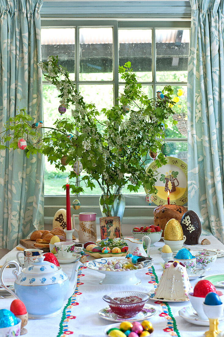 Easter eggs and teapot with spring blossom on table in Essex home, England, UK