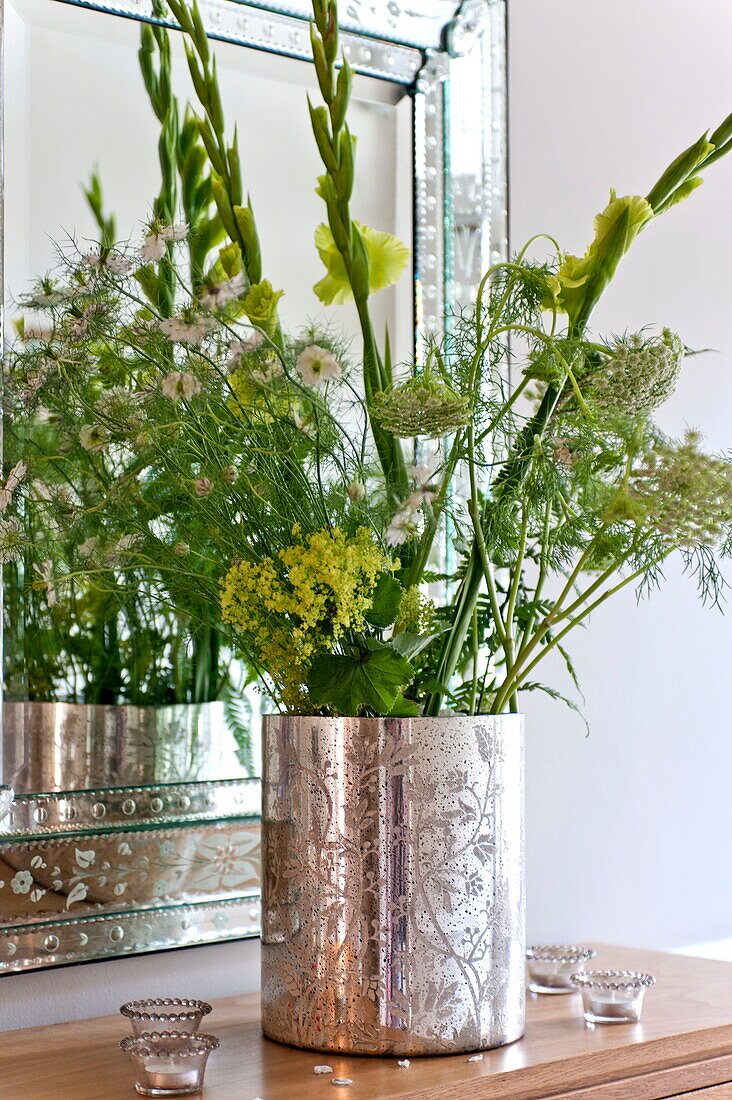Blumenarrangement in silberner Vase auf Anrichte im Haus einer Familie in Middlesex, London, England, UK