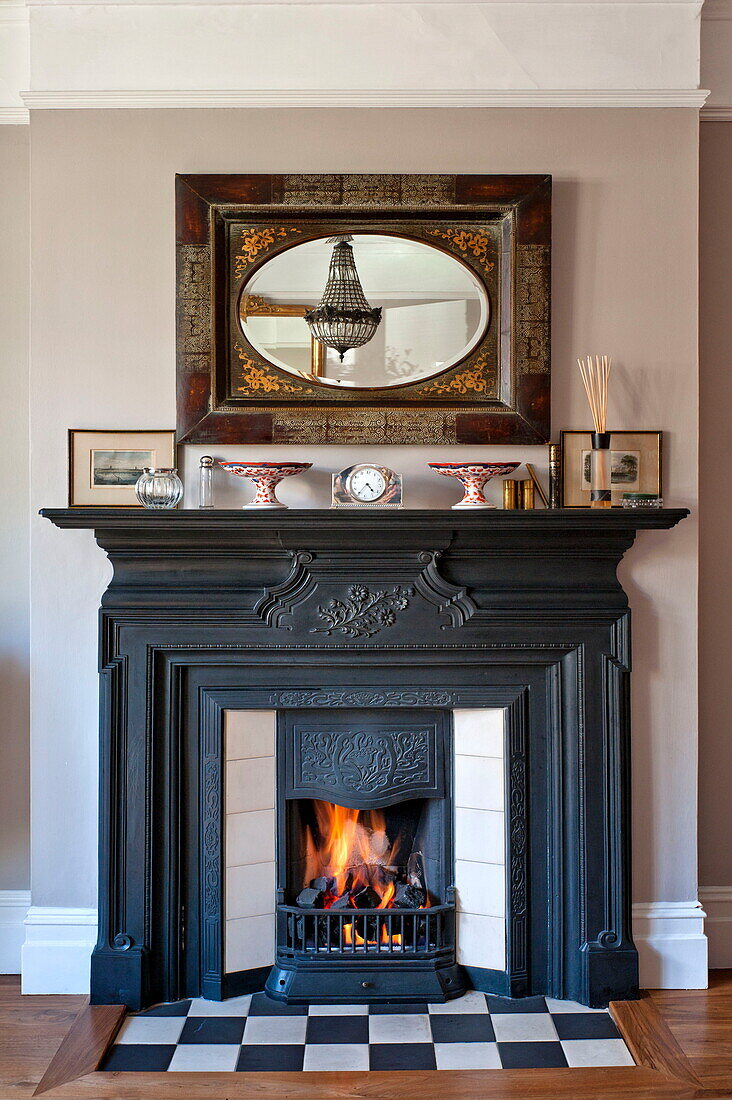 Beleuchtetes Feuer mit Ornamenten im Haus einer Familie aus Middlesex, London, England, UK