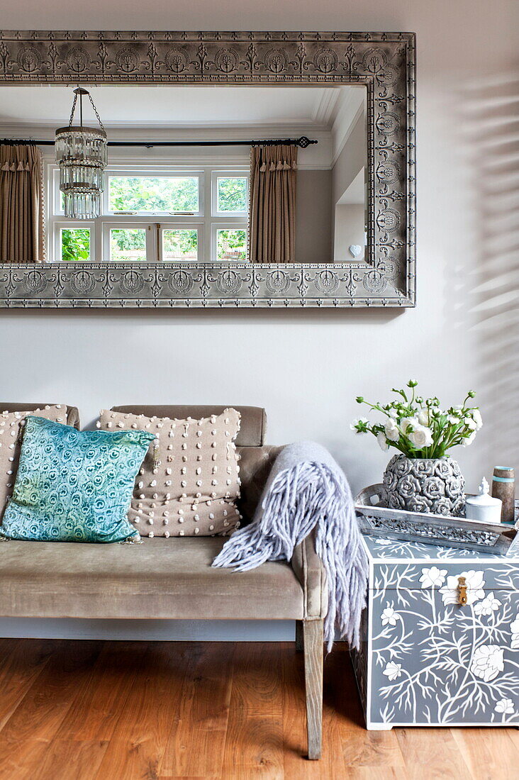 Blumenkasten mit dekorativem Spiegel und Sofa in einem Einfamilienhaus in Middlesex, London, England, UK