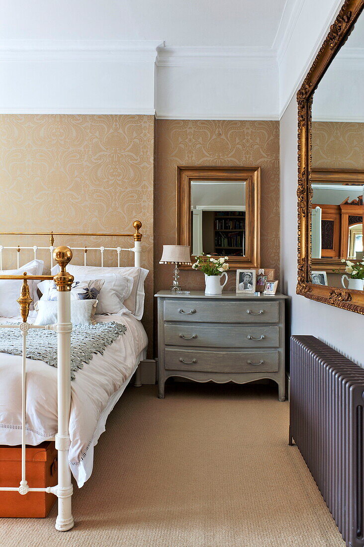 Gilt framed mirror above chest of drawers in bedroom of Middlesex family home, London, England, UK