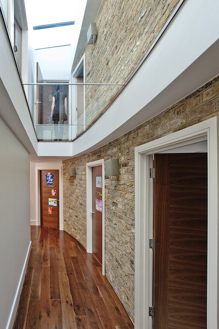 Double height, exposed brick hallway in London home, England, UK