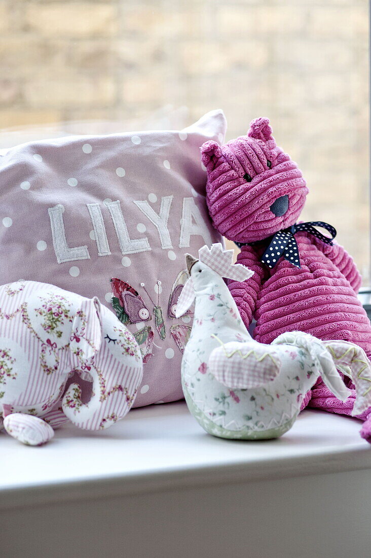Soft toys and spottyy cushion on windowsill in girls' room, London home, England, UK