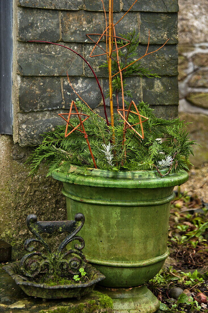 Christmas decorations and antique boot scraper outside farmhouse in Cornwall, England, UK