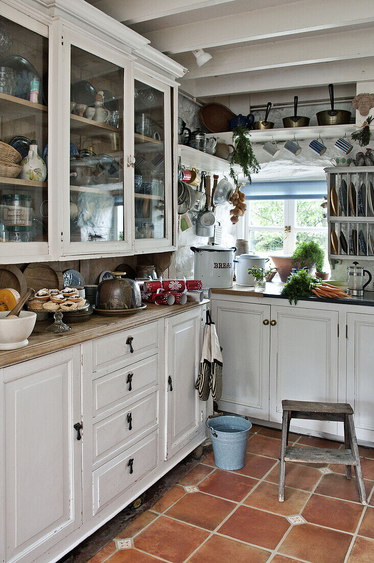 Glass fronted storage in farmhouse kitchen, Cornwall, England, UK