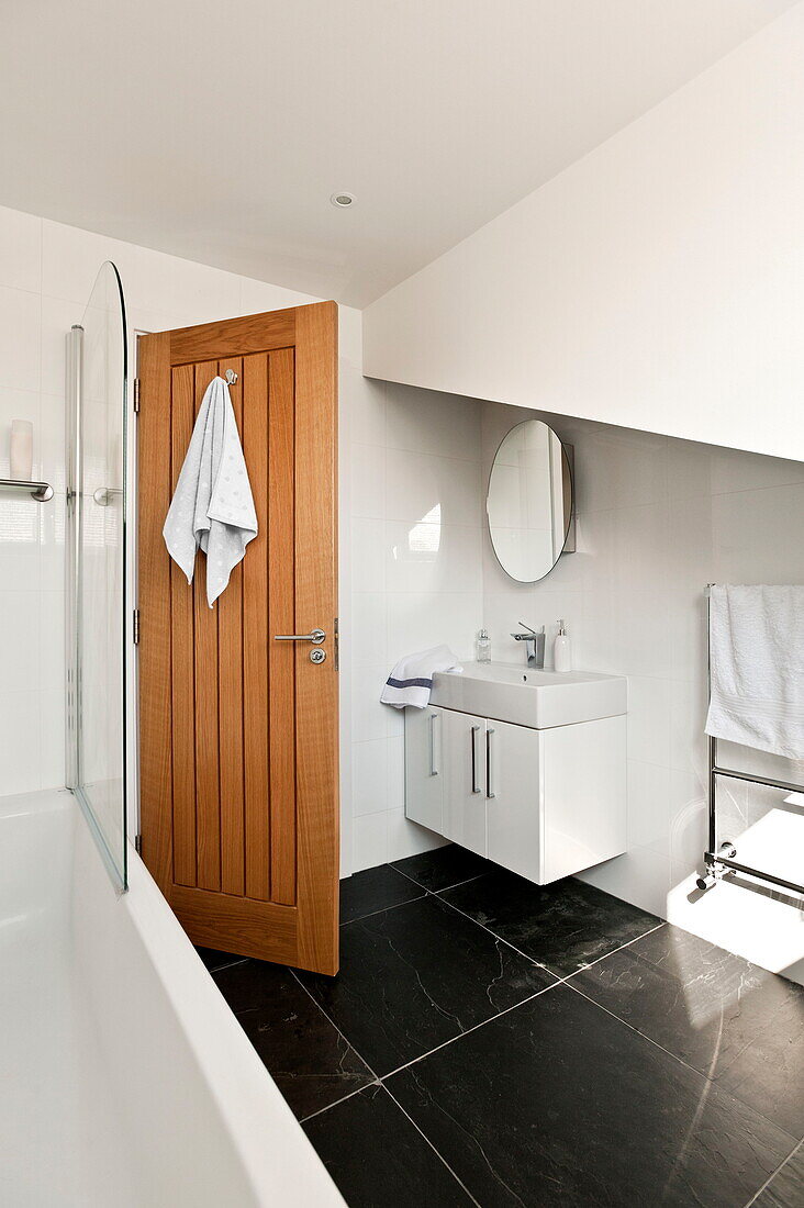 Holztür zu einem weißen Badezimmer in einem Haus in Wadebridge, Cornwall, England, UK