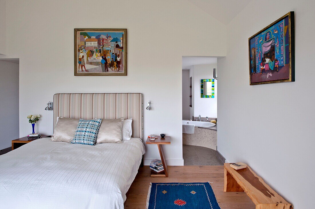 Blauer Teppich auf dem Boden eines Schlafzimmers mit eigenem Bad in einem modernen Haus, Cornwall, England, UK