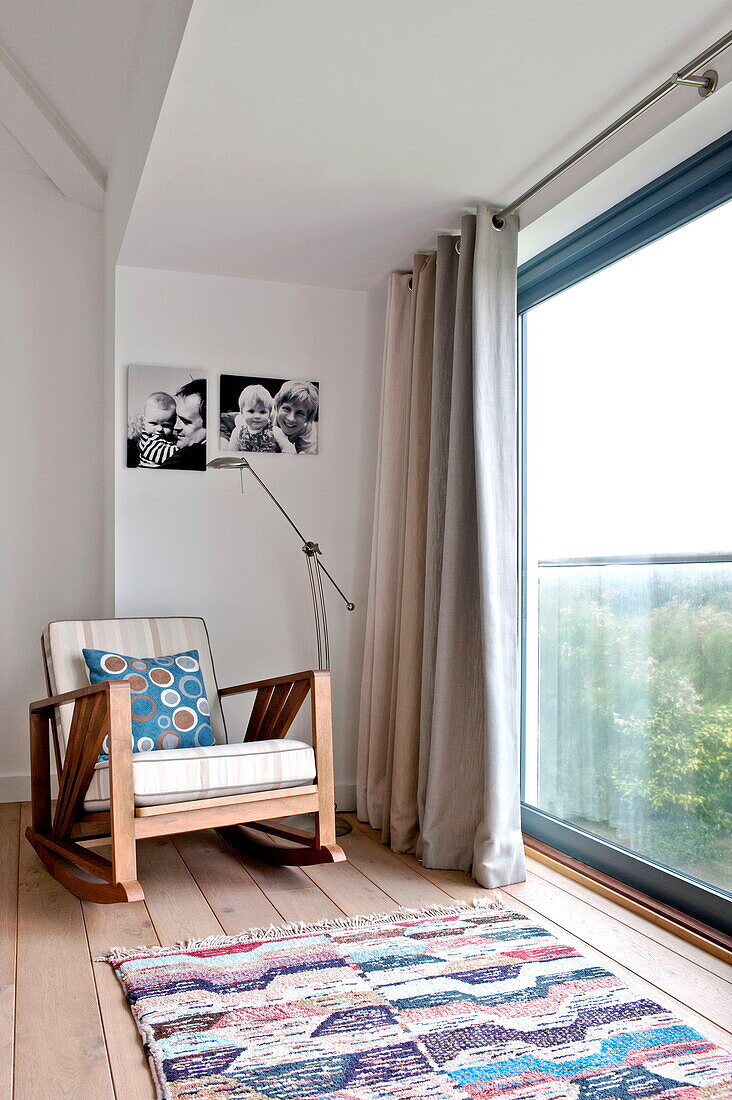 Holzschaukelstuhl am Schlafzimmerfenster in einem modernen Haus, Cornwall, England, UK