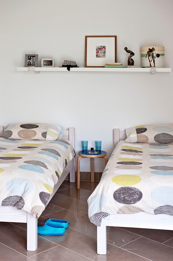 Zwillingsbetten mit großen Flecken auf Bettbezügen in einem modernen Haus, Cornwall, England, UK