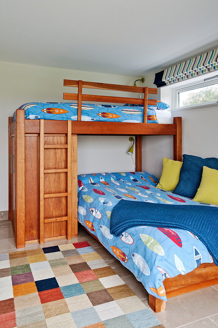 Blaue Bettdecken auf einem hölzernen Etagenbett in einem modernen Haus, Cornwall, England, UK