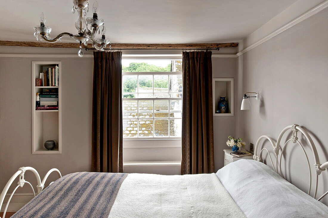Eingelassene Regale in einem Zimmer mit Wolldecke auf dem Bett in einem Cottage in Padstow, Cornwall, England, UK
