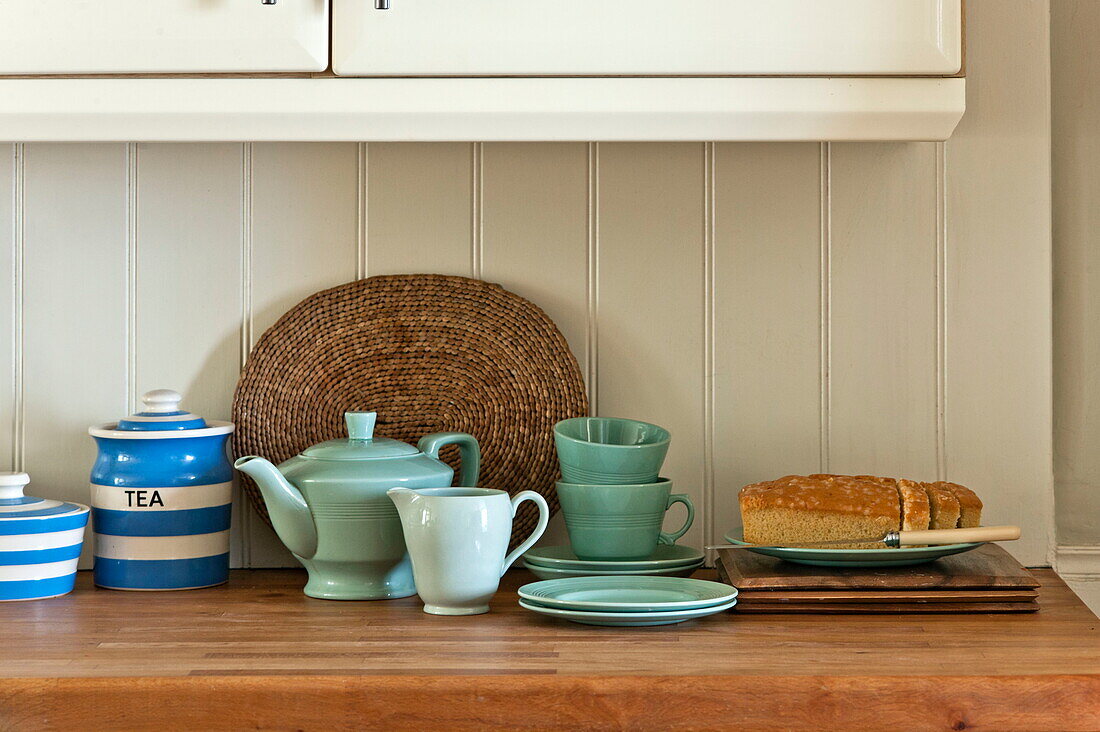 Teapot sea and cake with placemat on worktop in Padstow cottage kitchen, Cornwall, England, UK