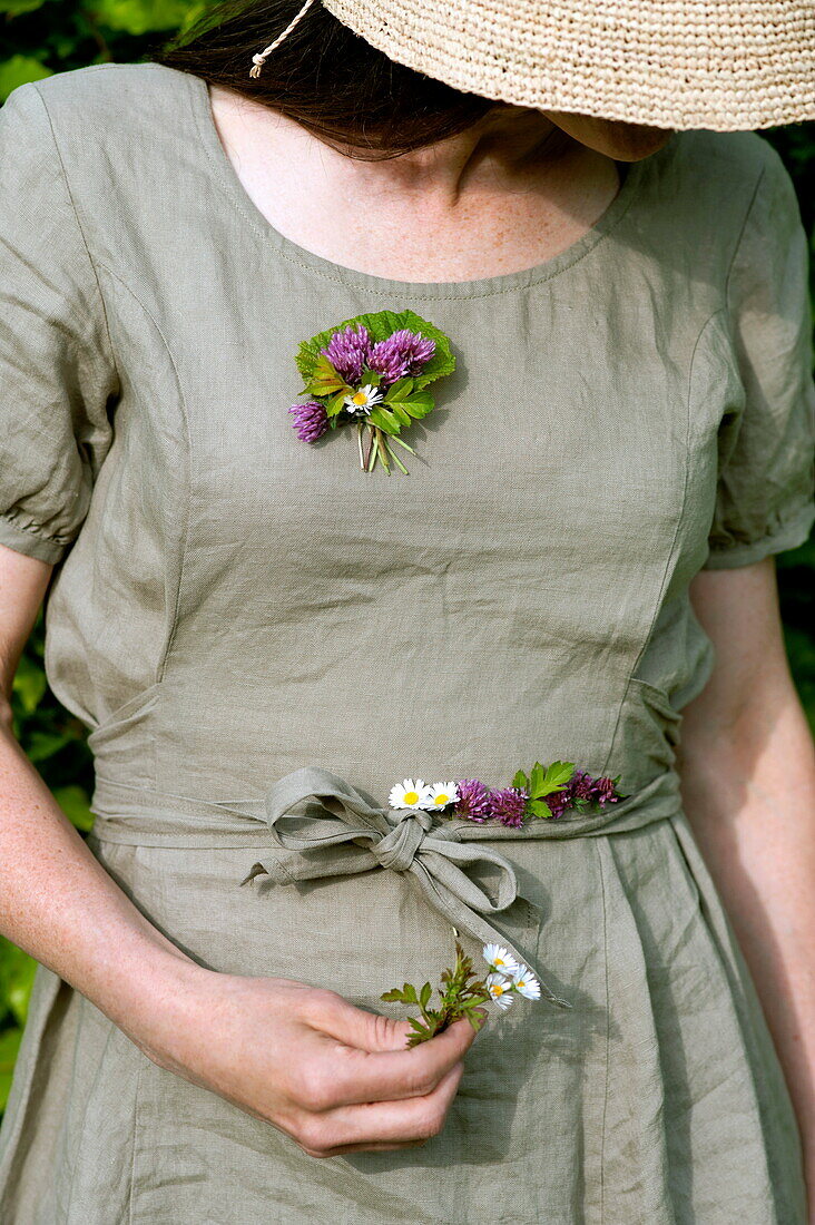 Woman in sunhat collecting wildflowers in Brecon, Powys, Wales, UK