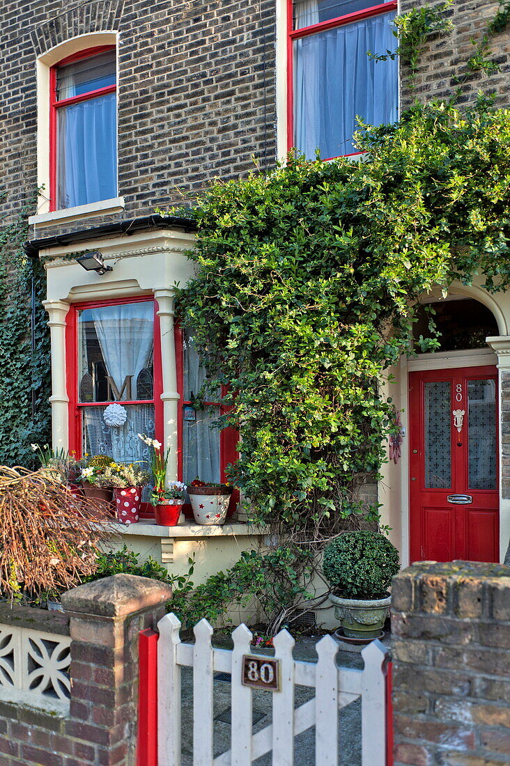 Red paintwork on brick exterior of London terraced house, England, UK