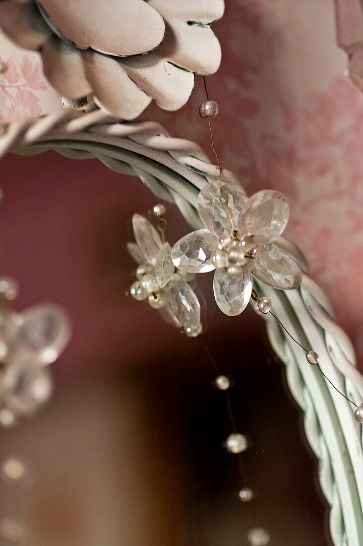Flower detail of jewelled vintage necklace and mirror frame in London home, England, UK