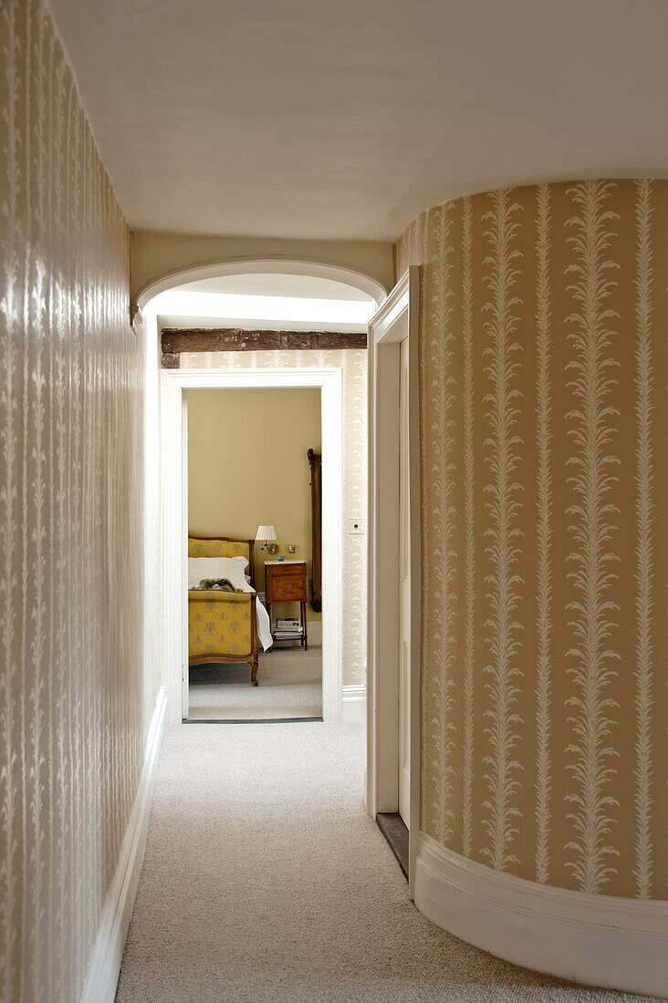 Curved wall with view through doorway to bedroom in contemporary Suffolk country house, England, UK