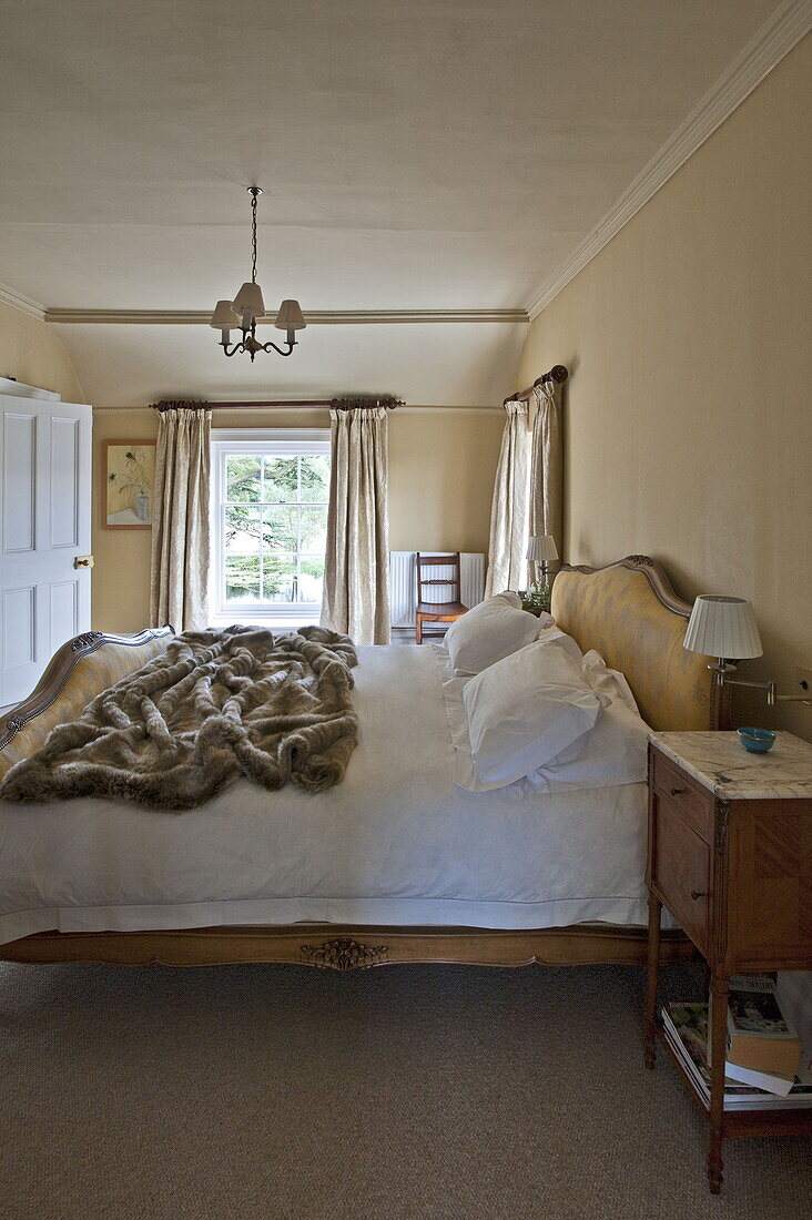 Doppelbett mit Fellüberwurf in einem modernen Landhaus in Suffolk, England, UK