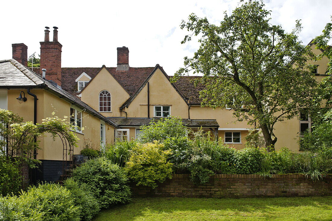 Ochre coloured house with garden exterior, Essex/Suffolk home, England, UK