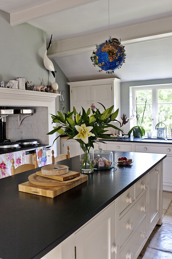 Cut lilies and chopping boards on worktop in contemporary Suffolk/Essex home, England, UK