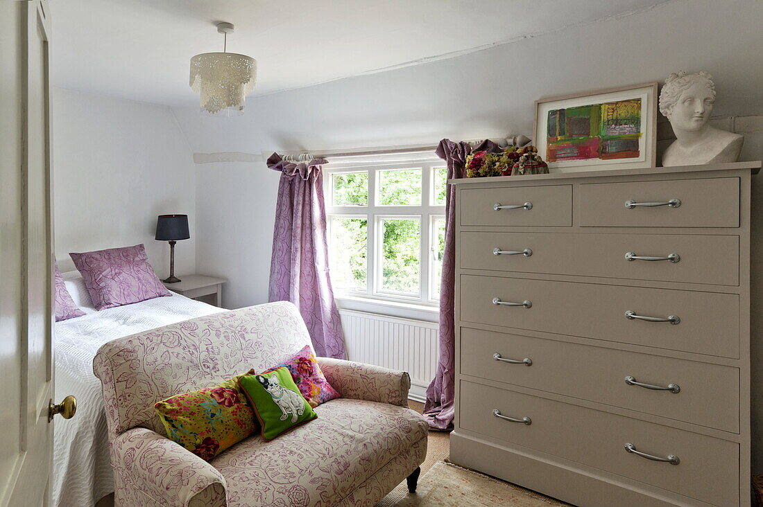 Two seater sofa and large chest of draws in small bedroom, contemporary Suffolk/Essex home, England, UK