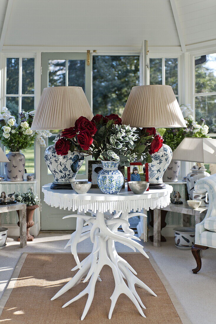 Matching lamps with blue ceramic bases on table in conservatory of Bury St Edmunds country home, Suffolk, England, UK
