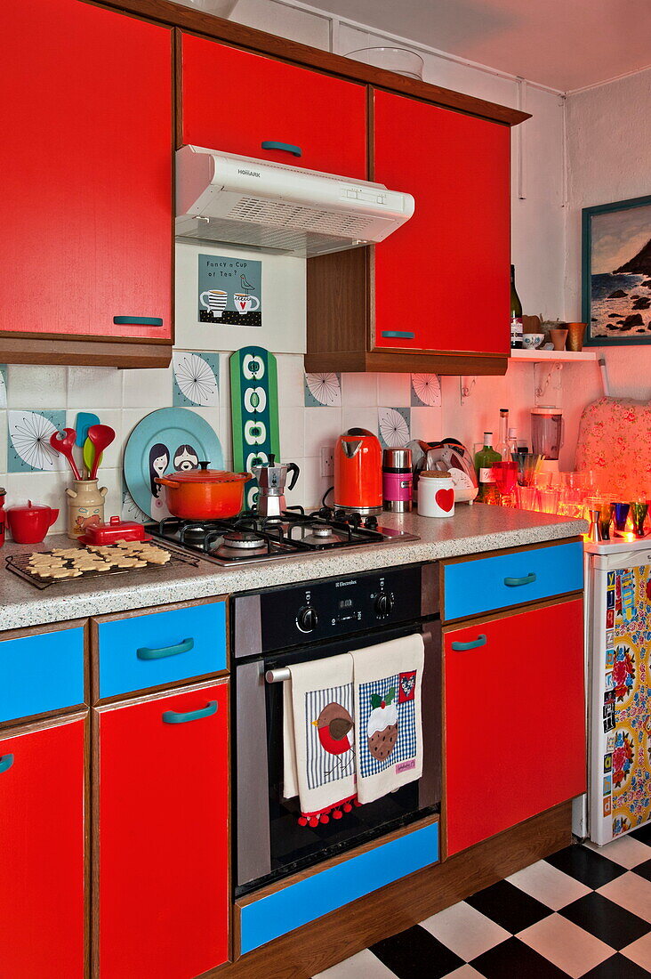 Rote und blaue Einbauküche mit Gaskochfeld in Penzance cottage Cornwall England UK