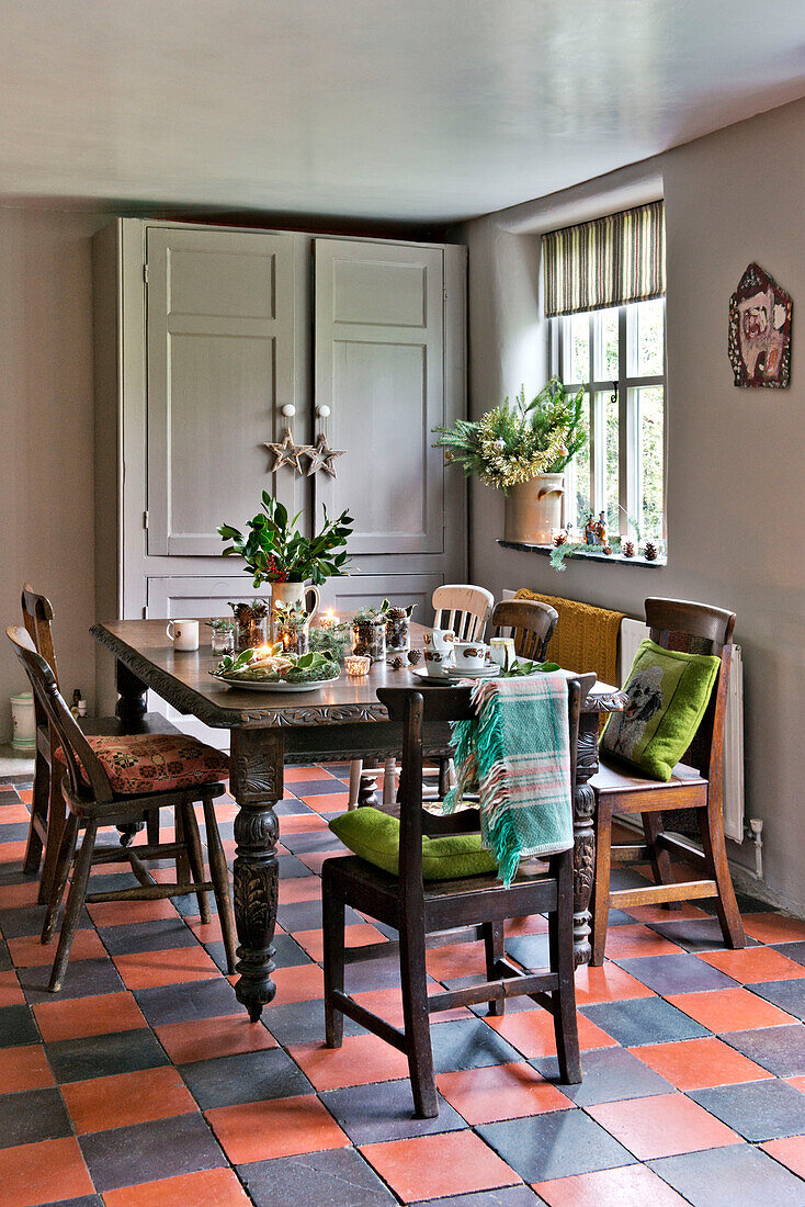Wooden table and chairs in terracotta tiled Tregaron home Wales UK