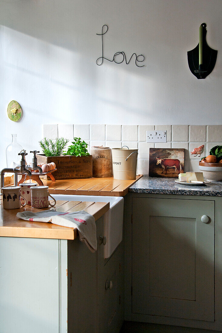 "Kräuter und Küchenutensilien mit dem Schriftzug Love"" auf einem Waschbecken in einer umgebauten Scheune in Sherford, Devon, Großbritannien"""