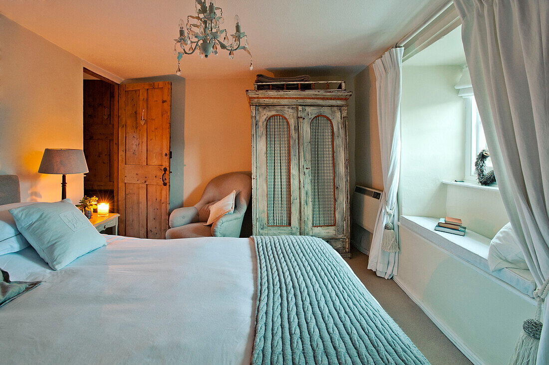 Painted wardrobe and windowseat in bedroom with woollen blanket in Sherford barn conversion Devon UK